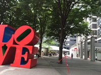 “LOVE”の奥のビルに入って頂きます。<br>この時、右手にセブンイレブンがあり、ビルの入り口をにはエクセルシオールカフェもございます。
